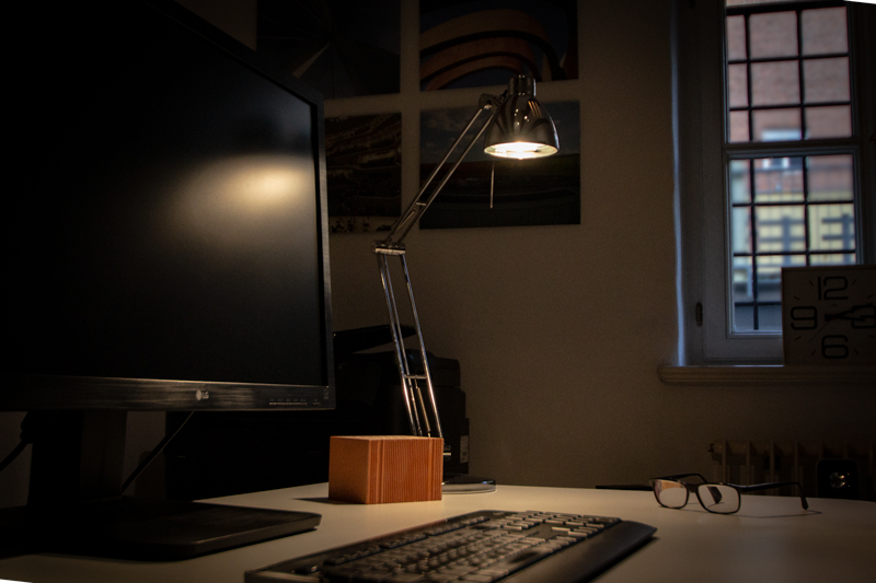 Schreibtisch mit Lampe und Bildschirm